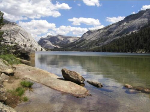 water with large rocks sticking out at edge of lake