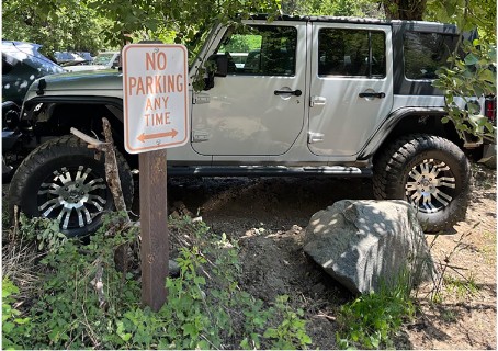 vehicle parked right behind no parking any time sign