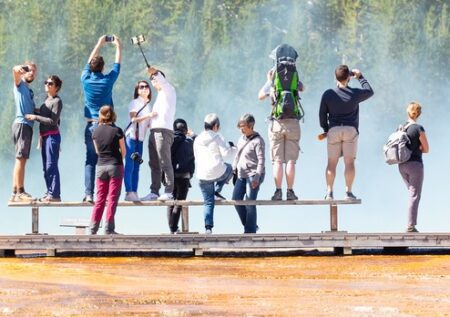 people standing on a bench on a boardwalk