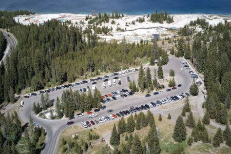 parking lot with geyser basin and part of lake above it