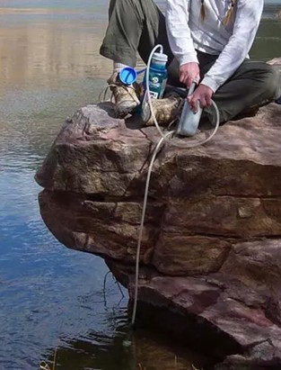 sitting on a large rock above a lake to pump water