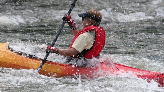 kayaker wearing lifejacket paddling in rough watrer