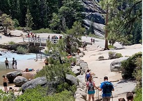 people on paths at top of a waterfall