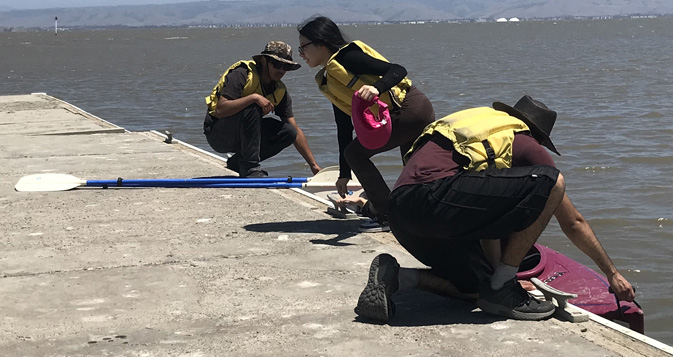 person steps out of kayak on to deck