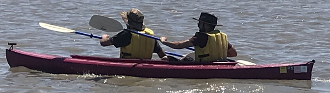 2 people in a kayak paddling the same way at the same time
