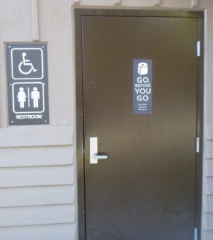 sign on restroom says Go Before You Go no toilets beyond this point